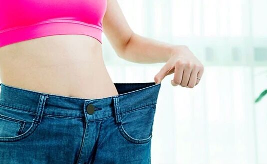 Overweight Thin woman wearing big jeans from when she was fatter