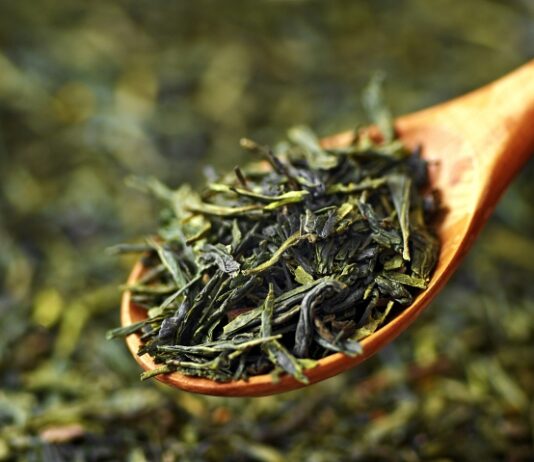 New Study: Green Tea Might Block Viral Growth Close up of dried green tea leaves on a wooden spoon