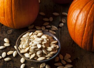 Pumpkin Seeds: Amazing Health Benefits Backed by Science Bowl of roasted pumpkin seeds surrounded by whole pumpkins