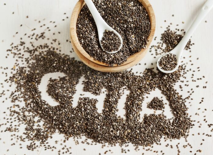 Chia Seeds Many tan chia seeds with the word chia spelled out between the seeds