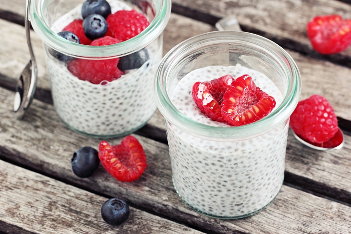Chia pudding in a glass bowl topped off with raspberry slices